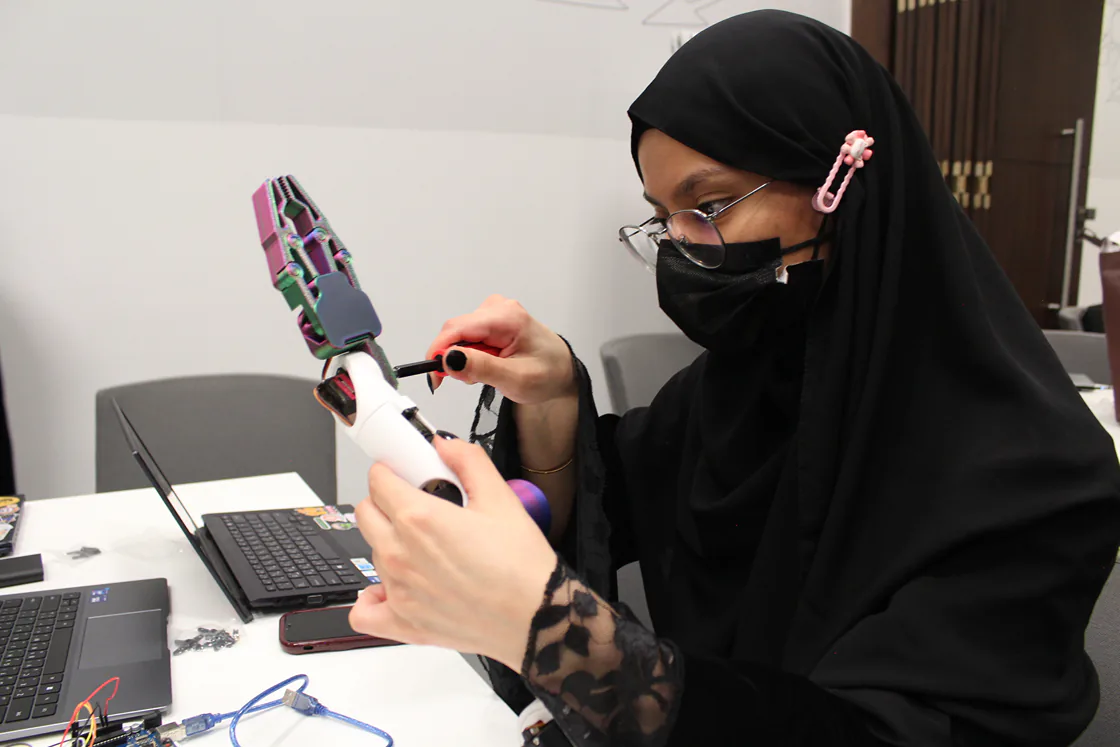 A participant assembling a robotic arm at an Aali workshop